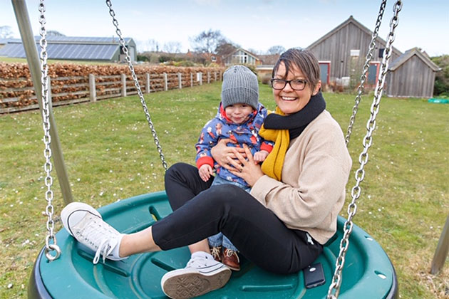 Happy users of one of the swings, swimming pool building behind, and Middleton Cottage (to right)